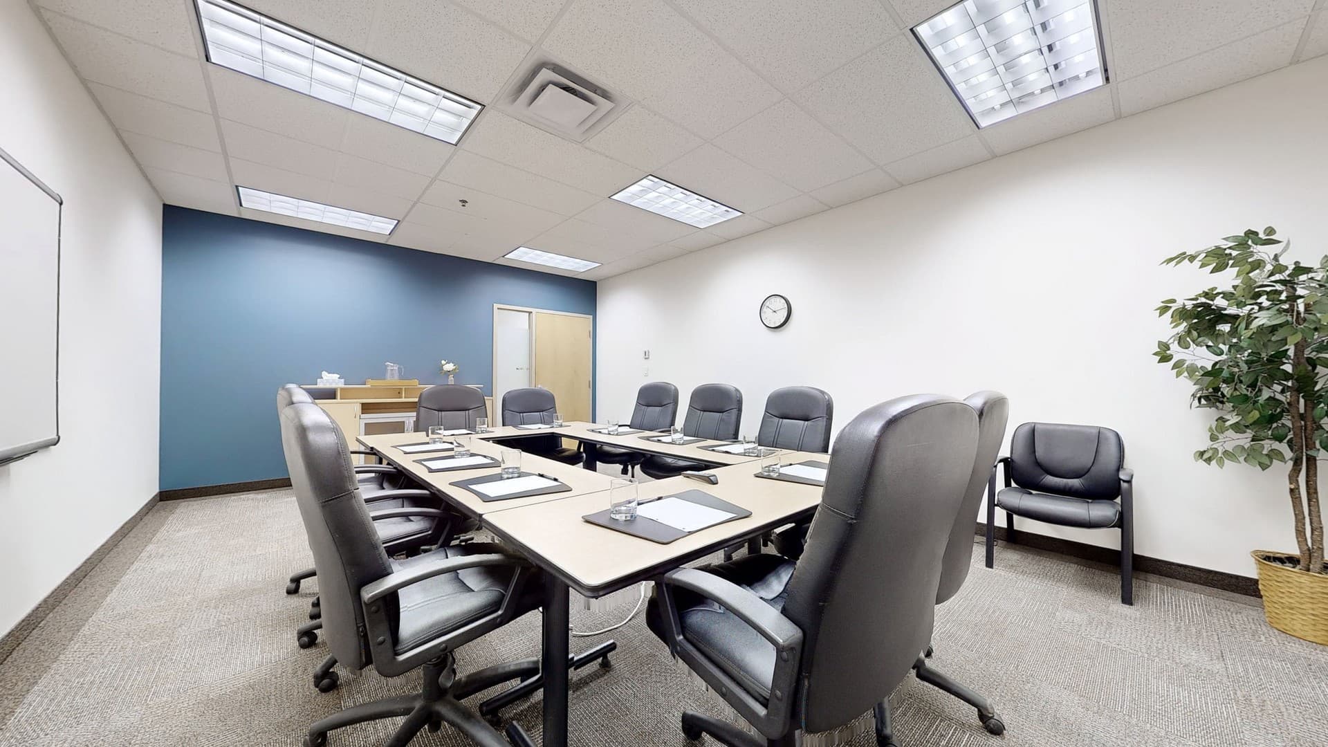 a boardroom with multiple chairs and a big tables